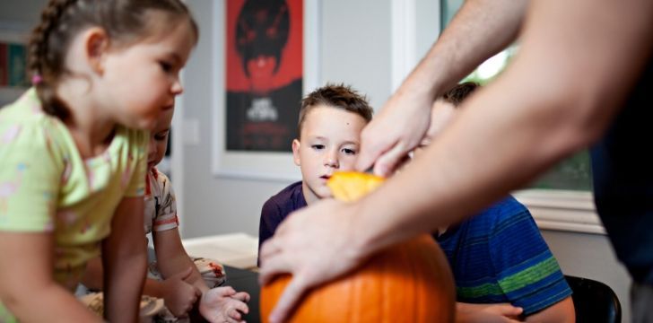 A family carving pumpkins for Halloween.