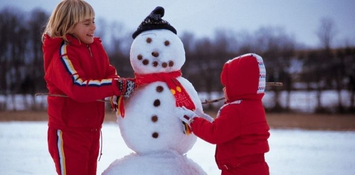 Two kids building a snowman