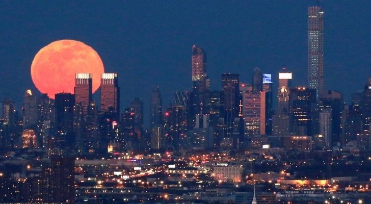 A pink superman shining above a city skyline