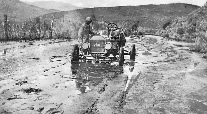 A Ford car trying to make its way through muddy ground