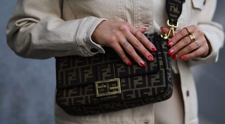 A person wearing the famous Fendi Baguette bag.