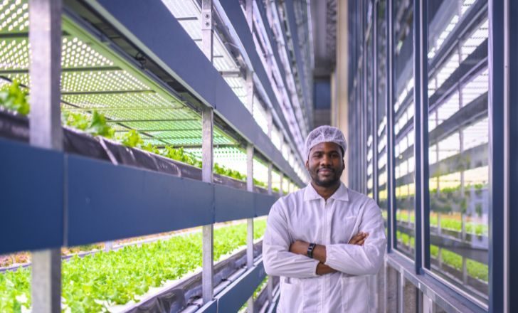 A man smiling next to a vertical farm.