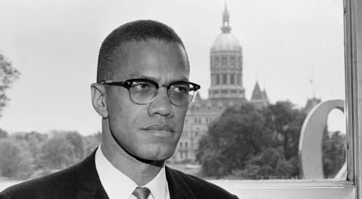 Malcom X with a building in the background