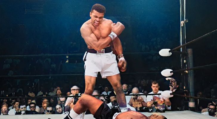 Muhammad Ali standing over his opponent in a boxing ring