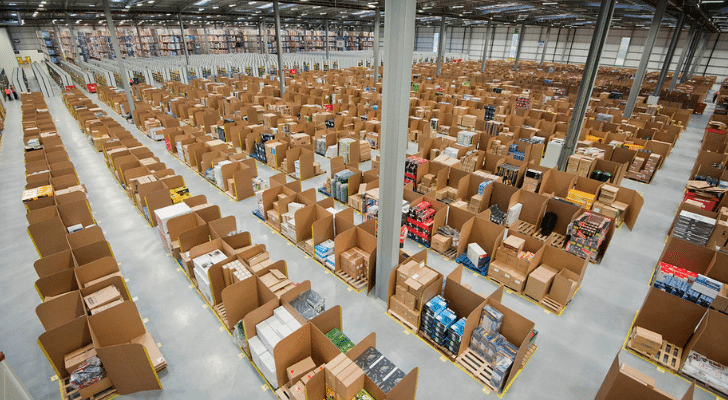 A huge warehouse with many cardboard boxes and items stacked into separate sections