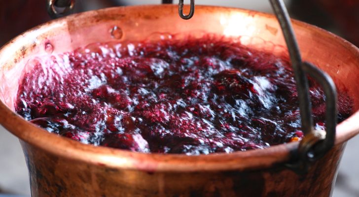 A large copper pot full of wine bubbles and boils