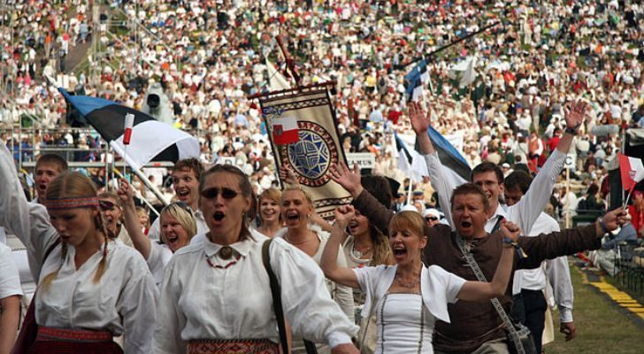 A huge crowd of Estonians gather with Estonian flags at a stadium for the "Laulupidu" singing festival