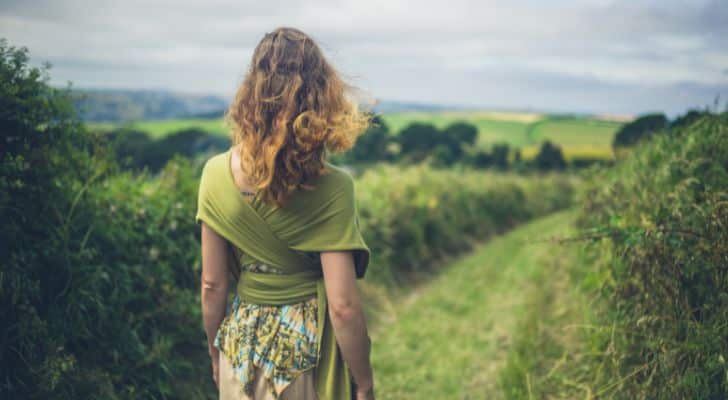 A woman walking peacefully through the countryside