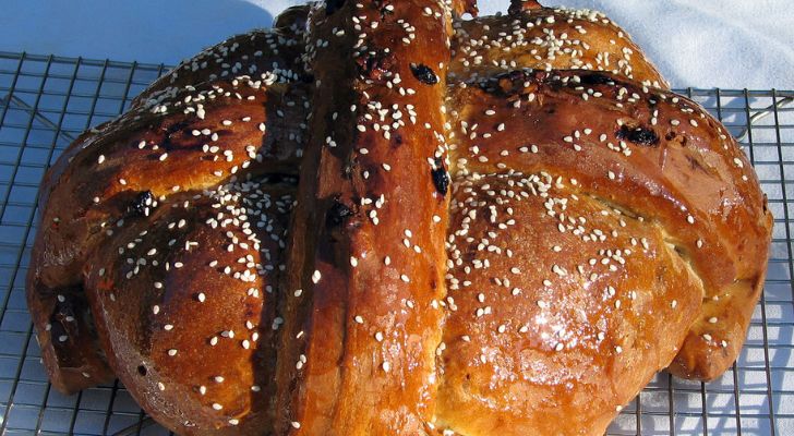 A seeded loaf of bread with a cross baked into its top