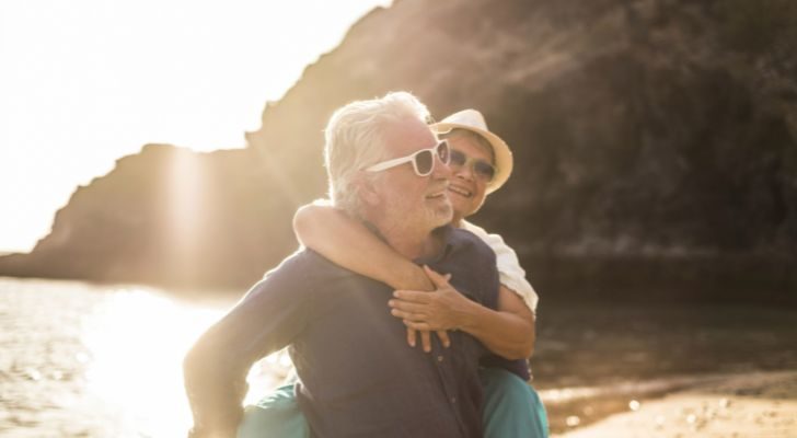 An older couple huging on the beach