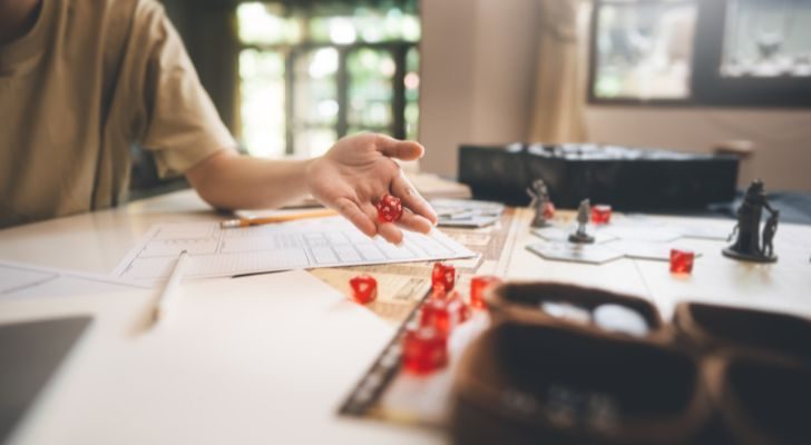 A person rolling dice as part of a Dungeons & Dragons game