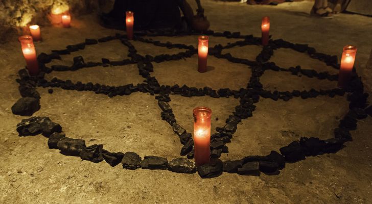 A pentagram with candles lit around it