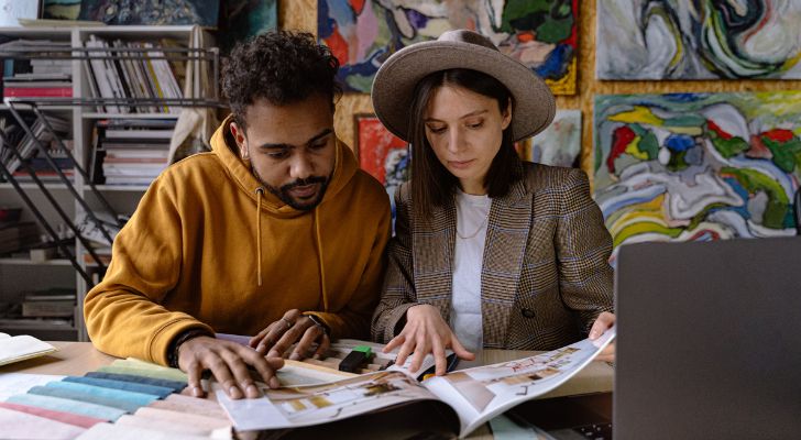 Two people looking at a furniture catalogue