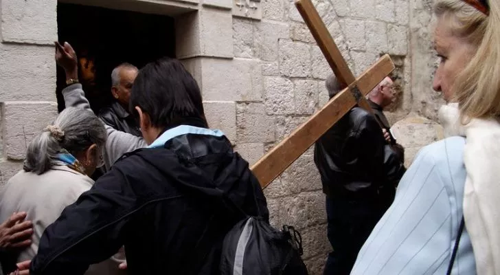 A man carrying a cross in Jerusalem as part of a procession