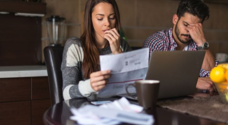 A couple looking at a pile of bills to pay