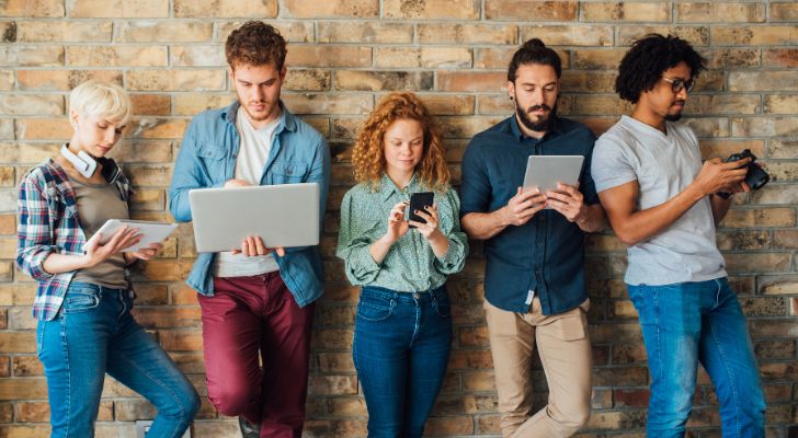 A group of millennials using electronic devices