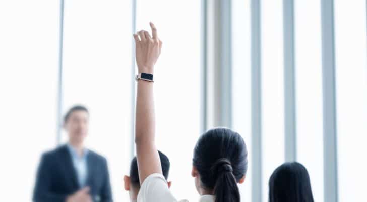 A woman in an office holding up her hand