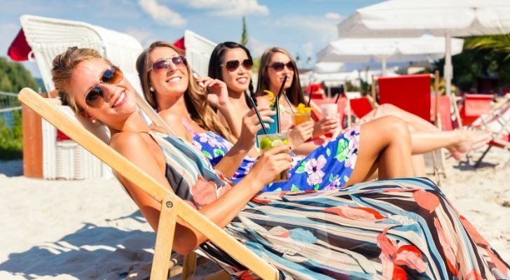 A group of women sitting in the sun at a beach