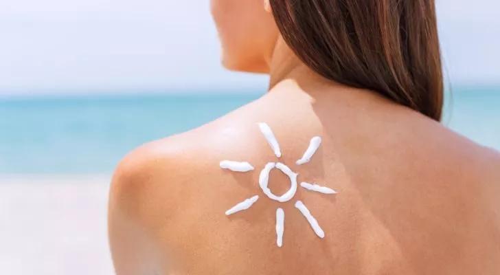 A sun made out of sunscreen on a woman's back