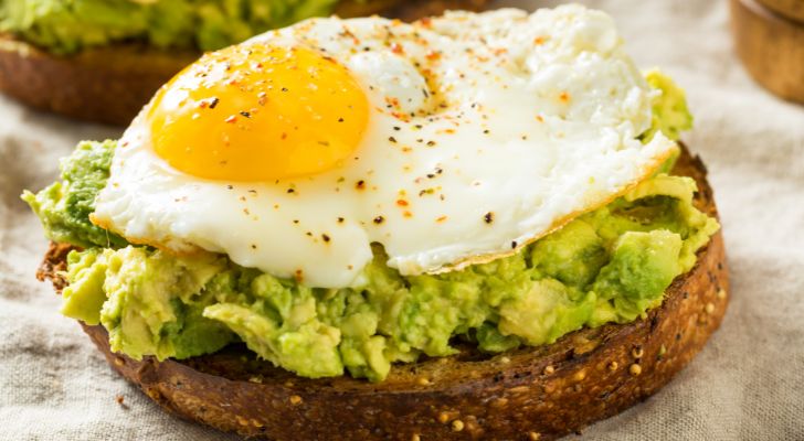 Mashed avocado spread on toast with a fried egg placed on top