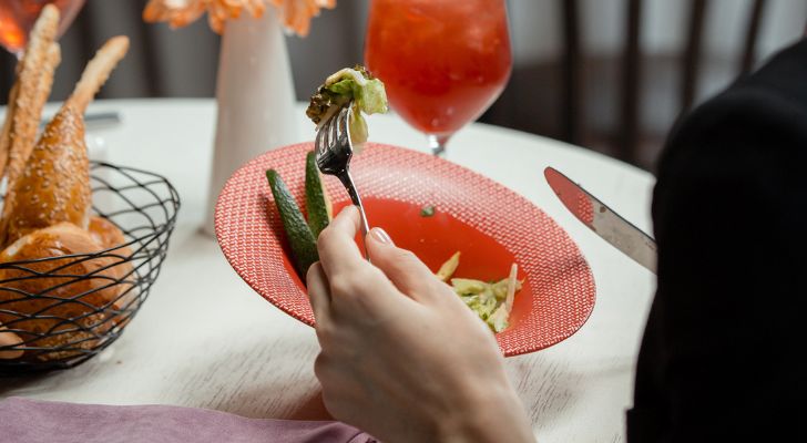 A person at a restaurant eating a meal which includes avocado