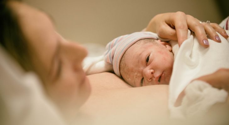 A mother holding her newborn baby on her chest after giving birth