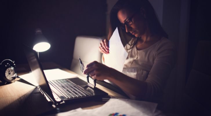 A woman stays up late working on her laptop