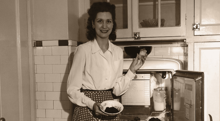 A woman in the 1950s standing in front of an open fridge