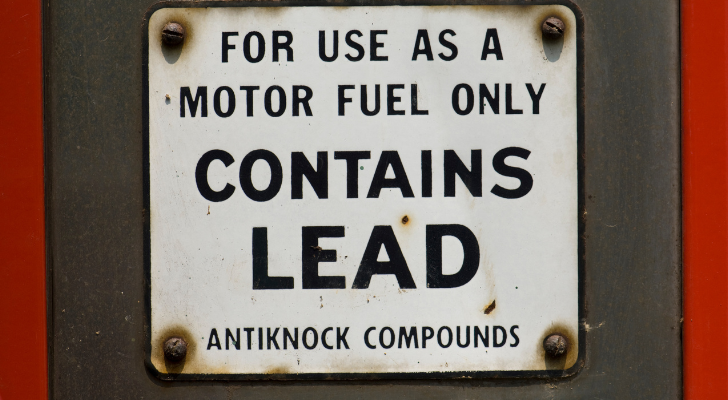 A sign on an old gas pump that says "Contains Lead"
