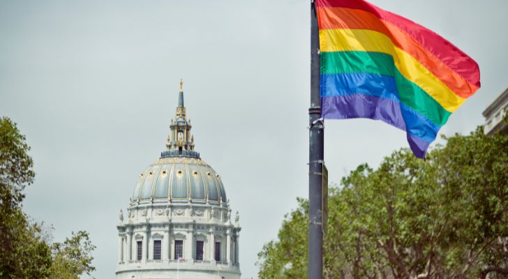 A pride flag flying from a pole in front of San Francisco's town hall