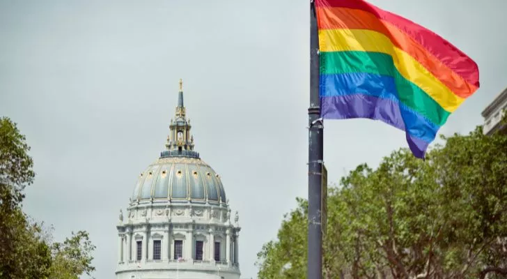 A pride flag flying from a pole in front of San Francisco's town hall