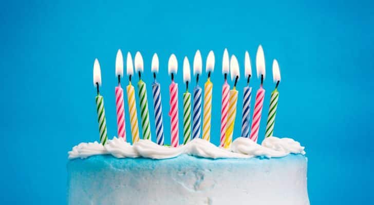 A birthday cake topped with many different colored candles