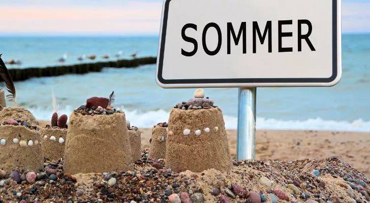 A sand castle built next to a sign that reads "Sommer"