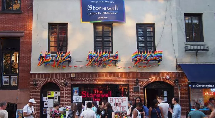 The Stonewall Inn with LGBT decorations and a crowd in front celebrating it becoming a national monument