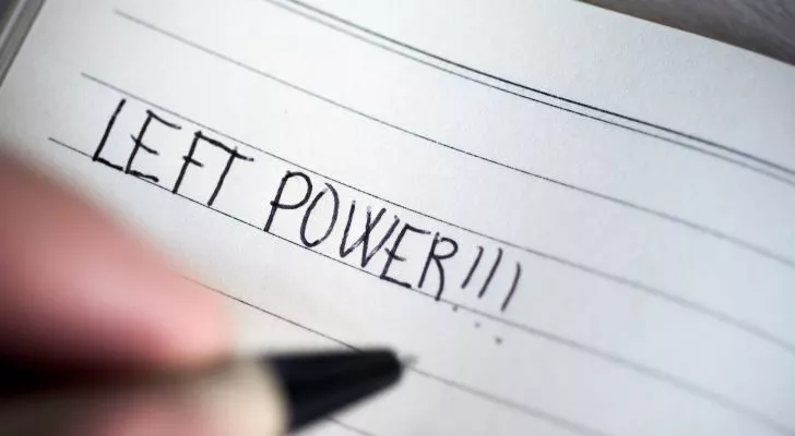 A left-handed person writing "Left power" in a notepad