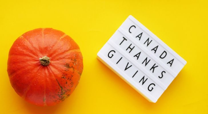 A pumpkin next to a sign that reads "Canada Thanks Giving"