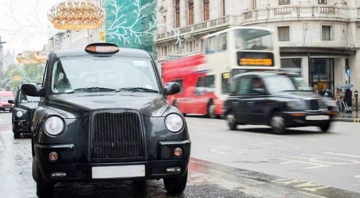 Several iconic London Black Cabs driving through the streets of London