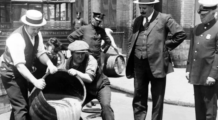 New York City police pour liquor out of a barrel after a prohibition raid