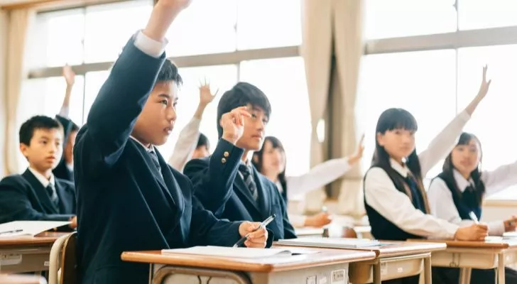 Japanese high school students raising their hand in a class