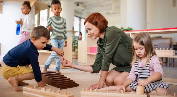 A teacher interacting with children in a Montessori classroom