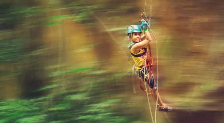 A child flying through the air on a zipline