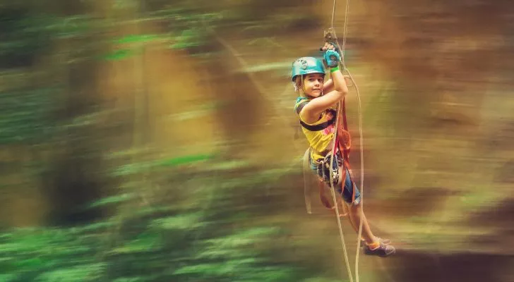 A child flying through the air on a zipline