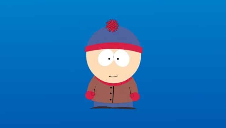 Stan Marsh from South Park wearing his iconic blue and red beanie, brown jacket, red mittens, and blue pants against a blue background.