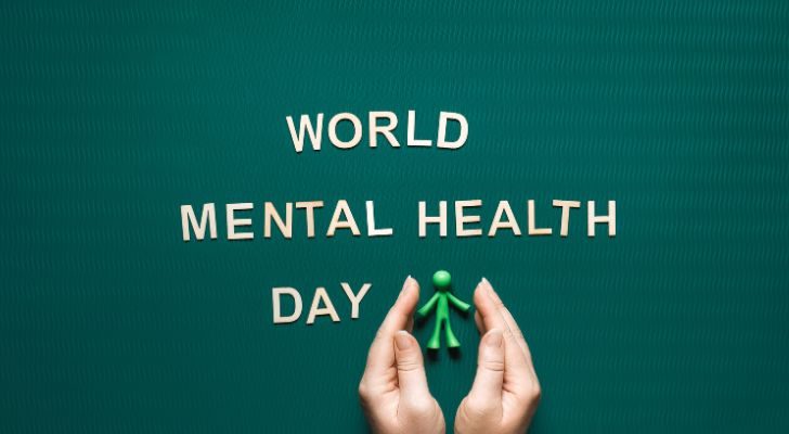 The words "World Mental Health Day" are placed next to a small green man figurine