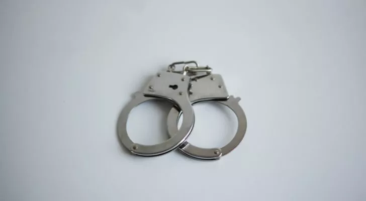 A pair of metal handcuffs placed on a table