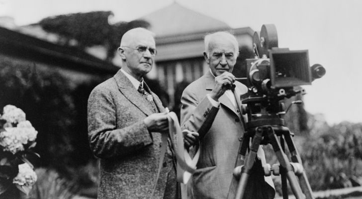 Thomas Edison and George Eastman standing alongside an old film camera