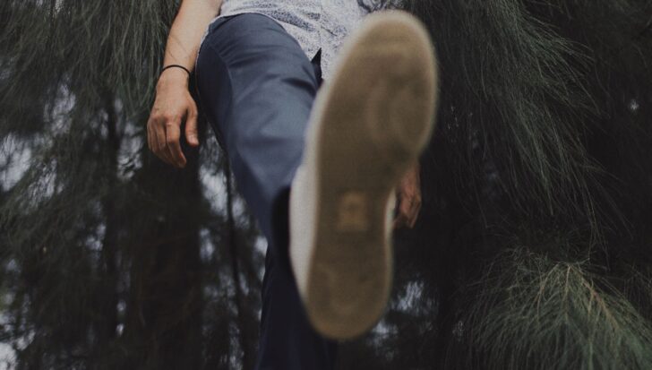 Person raising their leg while surrounded by trees