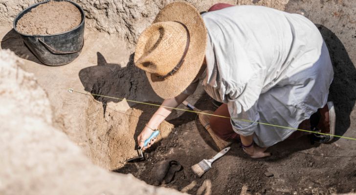 An archaeologist digging at an archaeological site