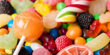 Colorful assortment of hard candies, including lollipops and gummies, with bright colors and diverse shapes