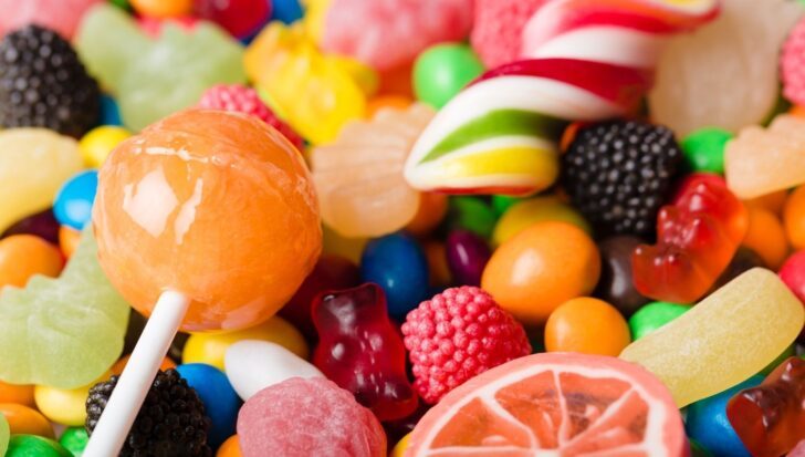 Colorful assortment of hard candies, including lollipops and gummies, with bright colors and diverse shapes